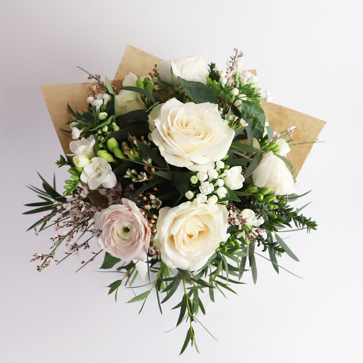 Overhead iew of bouquet with cream roses and pale pink ranunulus