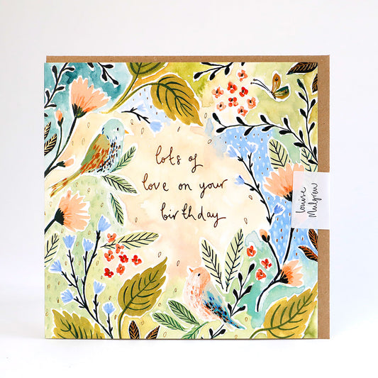 A greetings card illustrated in a painterly style with flowers and the words lots of love on your birthday