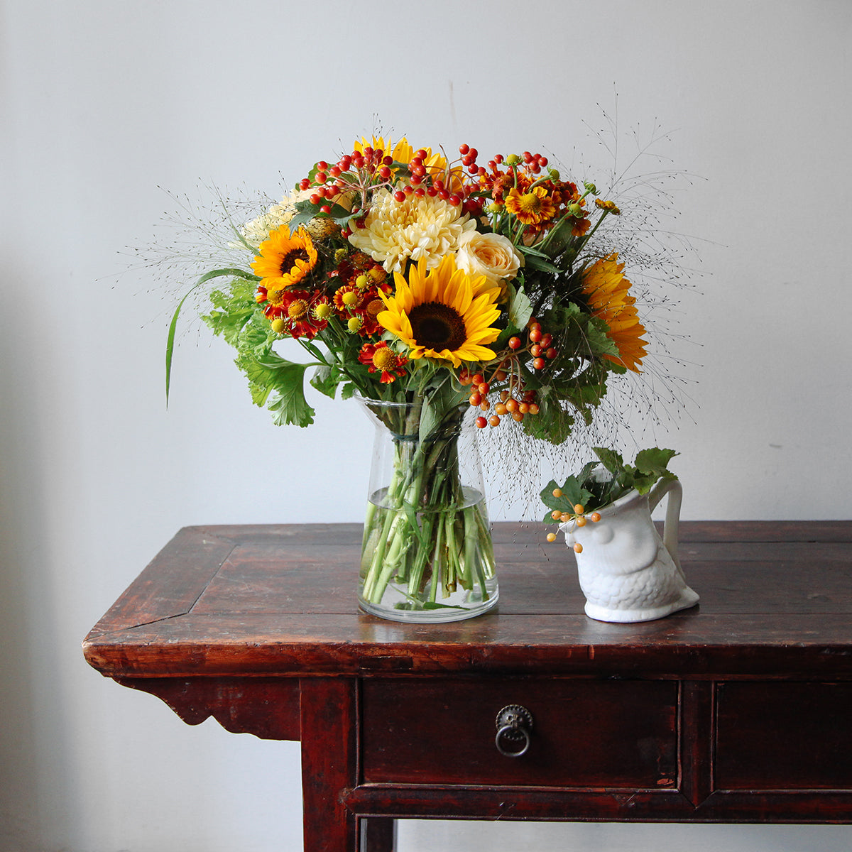 Sunflowers, blooms and yellow roses bouquet in a vase