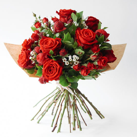 Bouquet of red roses and red spray roses and seasonal foliage