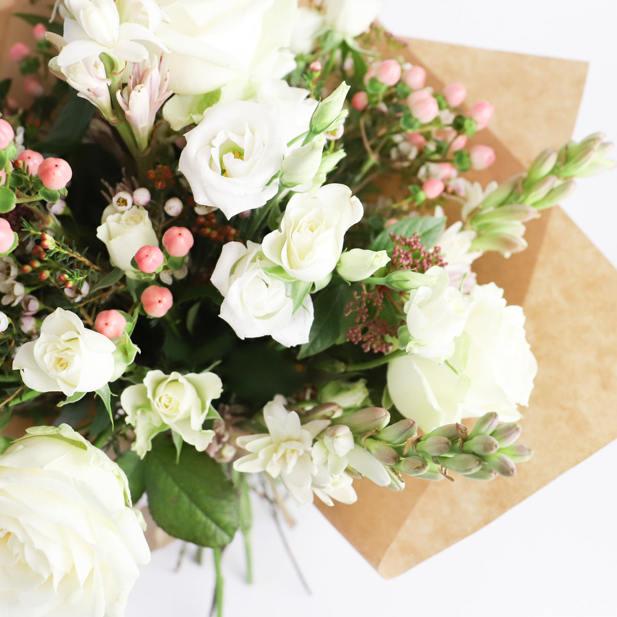 Detail view of white roses. pink hypericum and tuberose