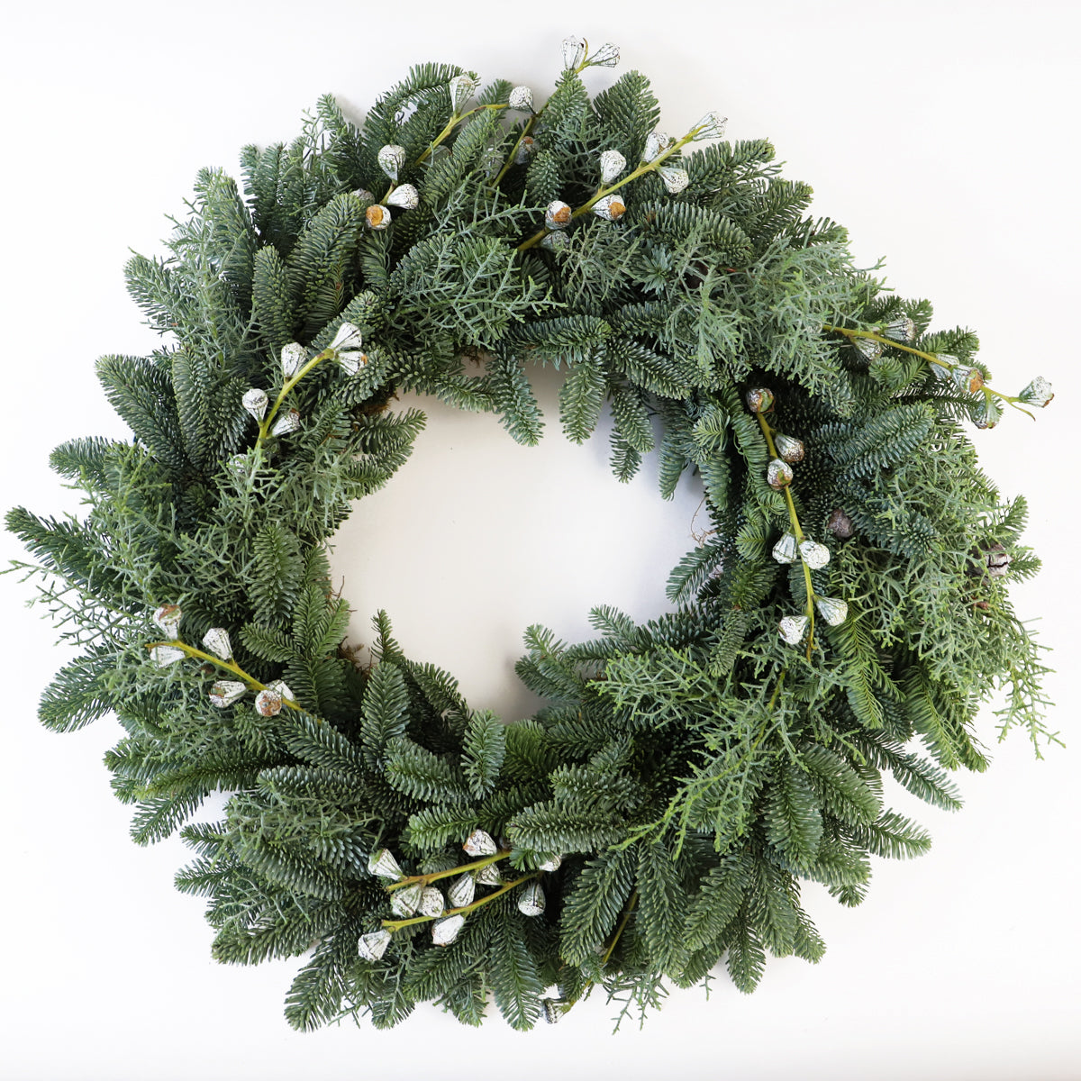 A pine christmas door wreath decorated with eucalyptus pods